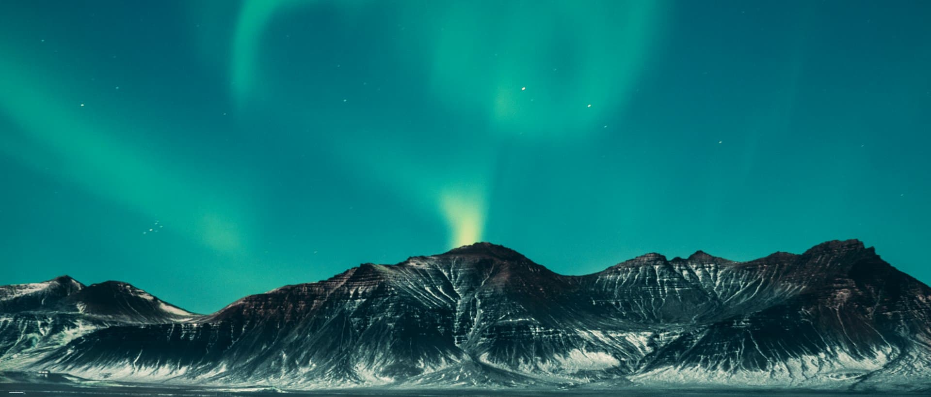 Northern lights over snow-covered mountains