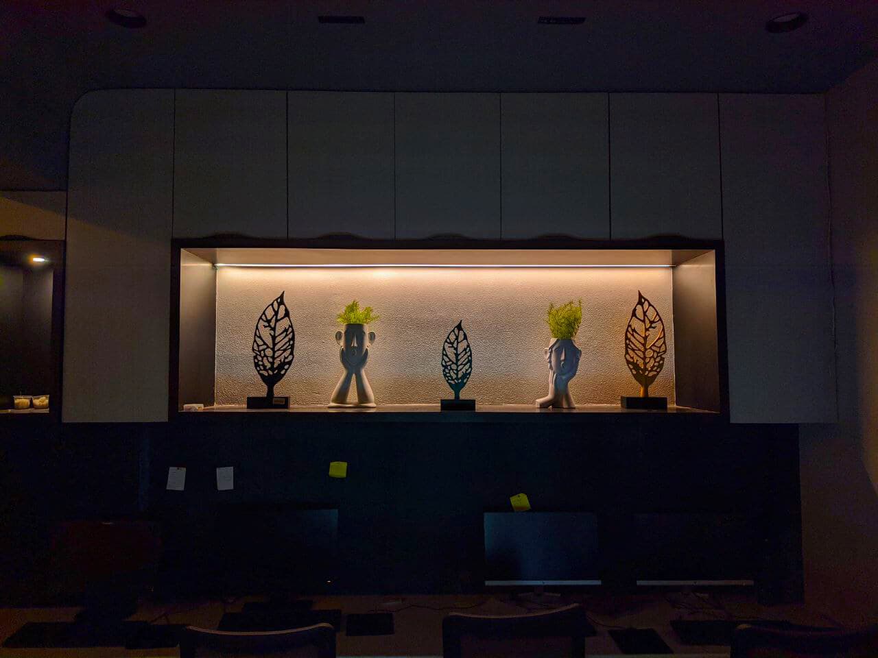 Backlit niche with sculptures above the workspace